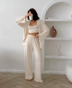Detailed texture of beige milk silk pajama set with ruffled tank top and wide leg pants