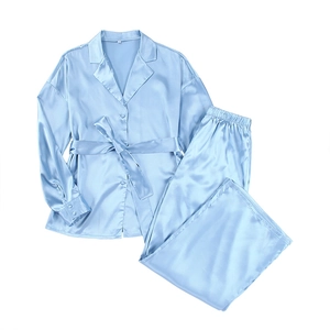 Pale blue satin pajamas set featuring long sleeve robe with belt and elastic pants