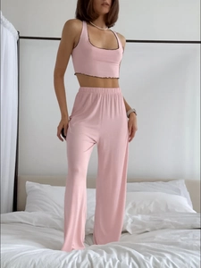 Detail of pink lounge set showing ruffled trim on crop top and high-waisted wide-leg pants