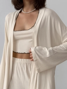 Detail of soft apricot milk silk three-piece lounge set with delicate black ruffle trim