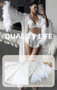 Macro shot of white satin pajamas with luxurious feather trim and refined seam stitching