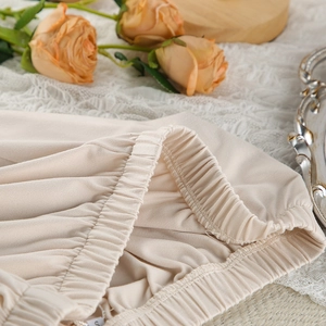 Detail view of the high-elastic waistband on apricot milk silk loungewear pants