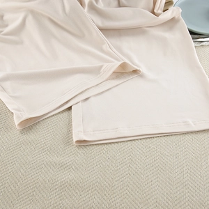 Detailed macro view of wide leg pajama trousers hem with premium stitching and soft milk silk fabric