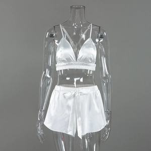 Detailed view of white satin lingerie set with V-neck camisole and bow shorts