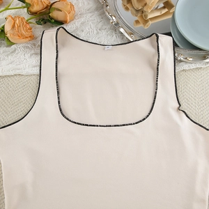 Detailed view of beige milk silk camisole with black stitched edges and size label