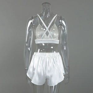 Detailed view of white satin pajama set featuring cross back straps and glossy fabric