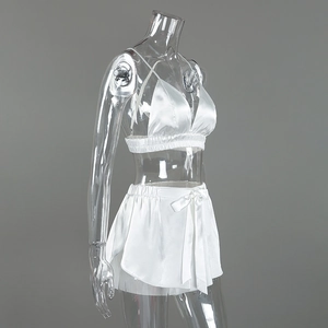 Detailed side view of white satin camisole and bow shorts set on transparent mannequin