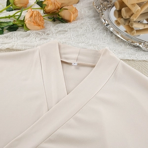 Close-up of beige milk silk pajamas collar with size S label and soft texture detail
