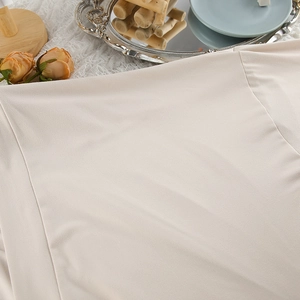 Close-up of apricot milk silk fabric texture and fine stitching on cozy pajamas