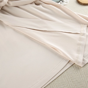 Detail shot of apricot milk silk fabric showing professional stitching and soft texture