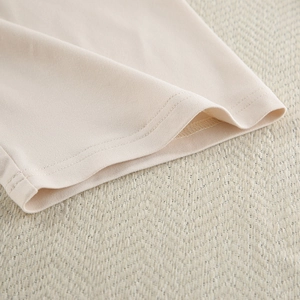 Detail shot of apricot milk silk loungewear showing premium double-stitched hem and soft fabric