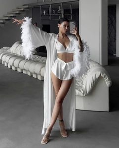 Close-up of white 3-piece satin loungewear set featuring luxurious feather-trimmed cuffs