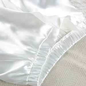 Detailed macro view of white satin pajamas elastic waistband with premium stitching