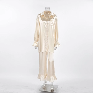 Detail van champagne satijnen pyjama met ruffelkraag en elastische mouwmanchetten