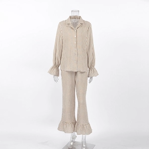Detail of cotton plaid pajamas featuring ruffled cuffs and button-down collar