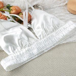 Detail of white satin camisole featuring elastic pleated hem and delicate thin straps