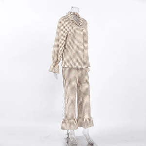 Detail of cotton plaid pajamas featuring ruffled edges on cuffs and button-down collar