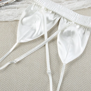 Detailed close-up of white silk pajama set featuring elastic waist and adjustable straps
