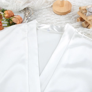Close-up of white satin sleepwear collar with silk texture and V-neckline detail