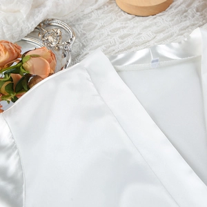 Detail of white satin robe neckline and smooth silk fabric texture with floral props