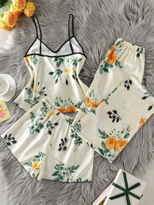 Ensemble de pyjama en satin ivoire à fleurs avec débardeur et pantalon sur tapis doux