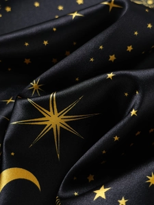 Detail of black silk satin fabric with gold star and moon patterns for pajamas