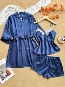 Three-piece dark blue satin pajama set with lace trim and matching robe on elegant floor