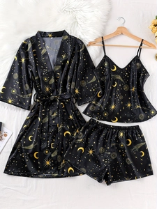 Detailed flat lay of black satin pajamas set with gold star and moon print