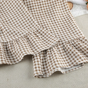 Detail view of cotton gingham pajama bottoms featuring a sweet ruffled hem and soft texture