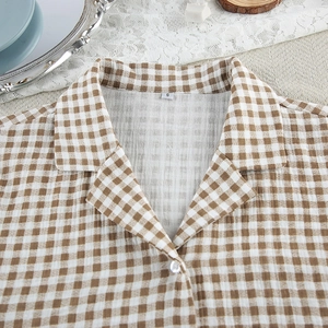 Detail of cotton plaid pajama top with a button-down collar and soft seersucker texture