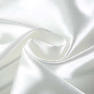 Close-up of white satin fabric with smooth silk texture and elegant draping effect
