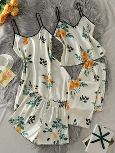Détail d'un ensemble de pyjama 4 pièces en satin avec imprimé floral orange et bretelles