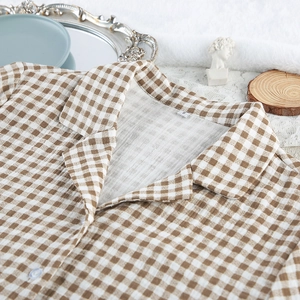 Detail of cotton plaid pajamas showing the lapel collar and size S tag on flat lay