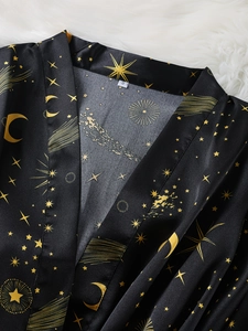 Detail of celestial moon and star patterns on premium black satin robe with size S label