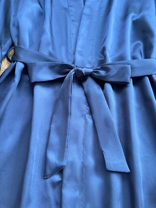 Detail showing the adjustable waist tie bow on navy blue satin silk pajamas set