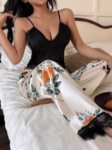 Detail of floral satin trousers with black lace hem and black lace camisole top