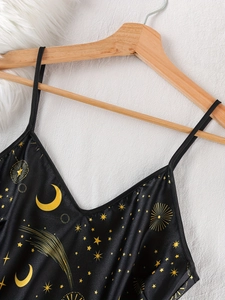 Detailed V-neck of black satin sleepwear with yellow star and moon celestial print