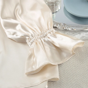 Detail van de elastische ruchesmanchetten van de champagnekleurige satijnen pyjamastop