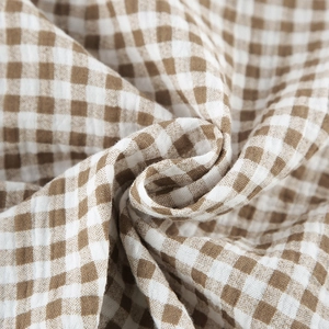 Close-up of brown and white checkered cotton fabric showing soft texture and weave