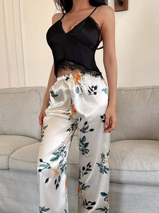 Detailed view of floral satin pajama set with black lace trim on the camisole top