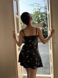 Back view of black satin nightgown featuring golden sun, moon and star celestial prints