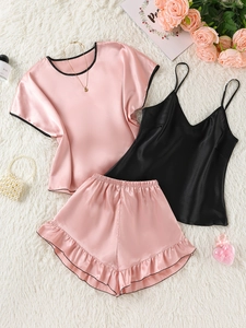 Flat lay of satin 3-piece pajama set with pink contrast trim and ruffle hem details