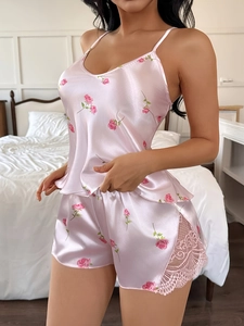 Detalle de camisola de satén rosa con estampado de rosas y encaje en los pantalones