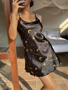 Close-up of black satin nightgown with gold star and moon prints and delicate straps