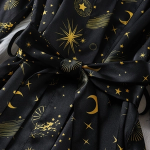 Satin pajama robe set with celestial sun moon and star gold patterns on black fabric