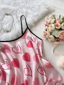 Detail of pink satin camisole with love heart patterns and black lace contrast trim