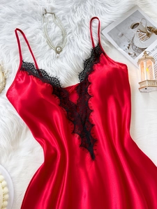 Détail d'une nuisette en satin rouge avec dentelle noire et décolleté plongeant en V