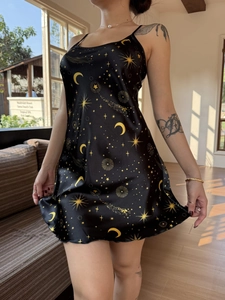 Detail of black satin nightgown featuring celestial gold star and moon prints