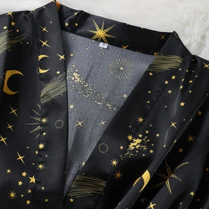 Women's black satin pajama set with gold star and moon patterns for a luxury nightwear look