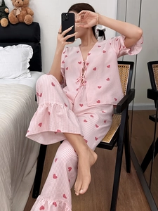 Detail of pink striped pajamas with red hearts and ruffled edges on sleeves and hem